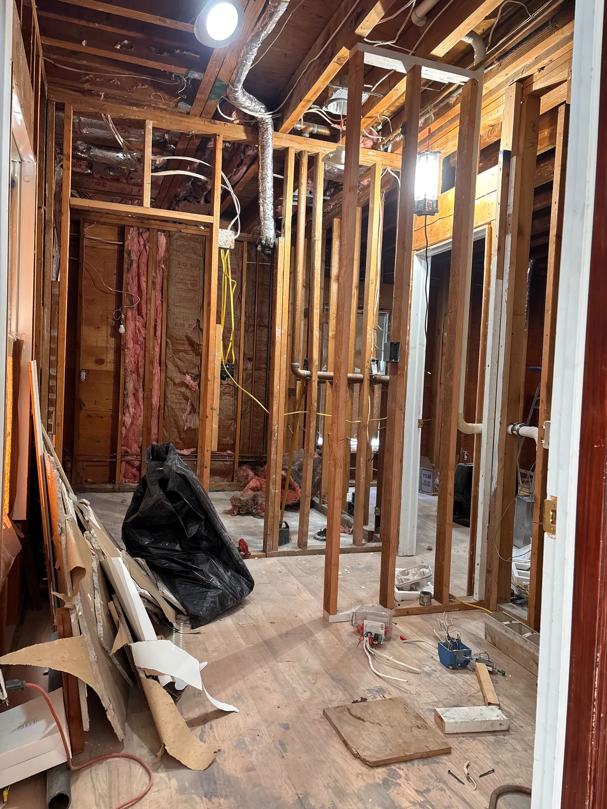 Exposed wood wall studs and ceiling framing during construction